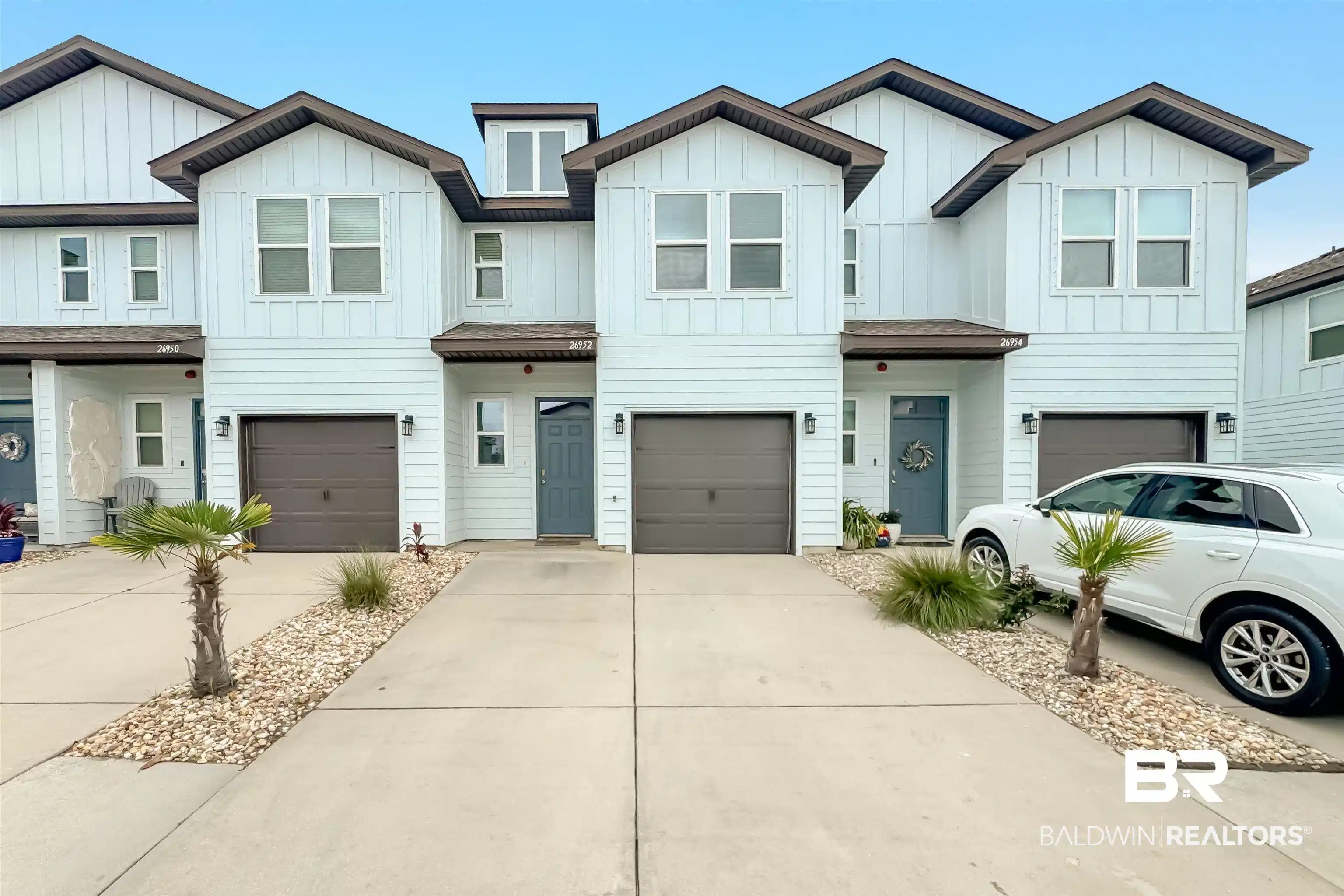 Image 1: Contemporary townhome exterior featuring light-colored horizontal siding and dark brown trim accents
