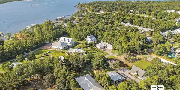Image 2: Aerial perspective showcasing waterfront properties along a tree-lined shore