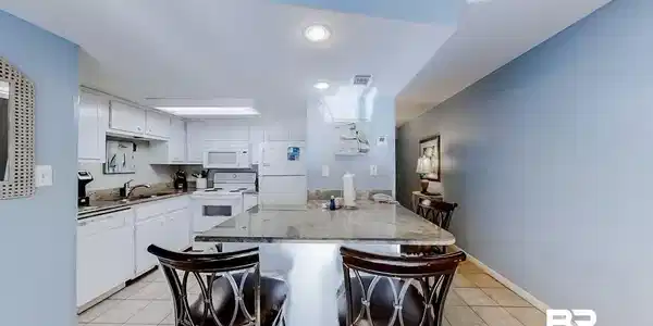 Image 3: Kitchen featuring white cabinetry, white appliances, a center island, and sink