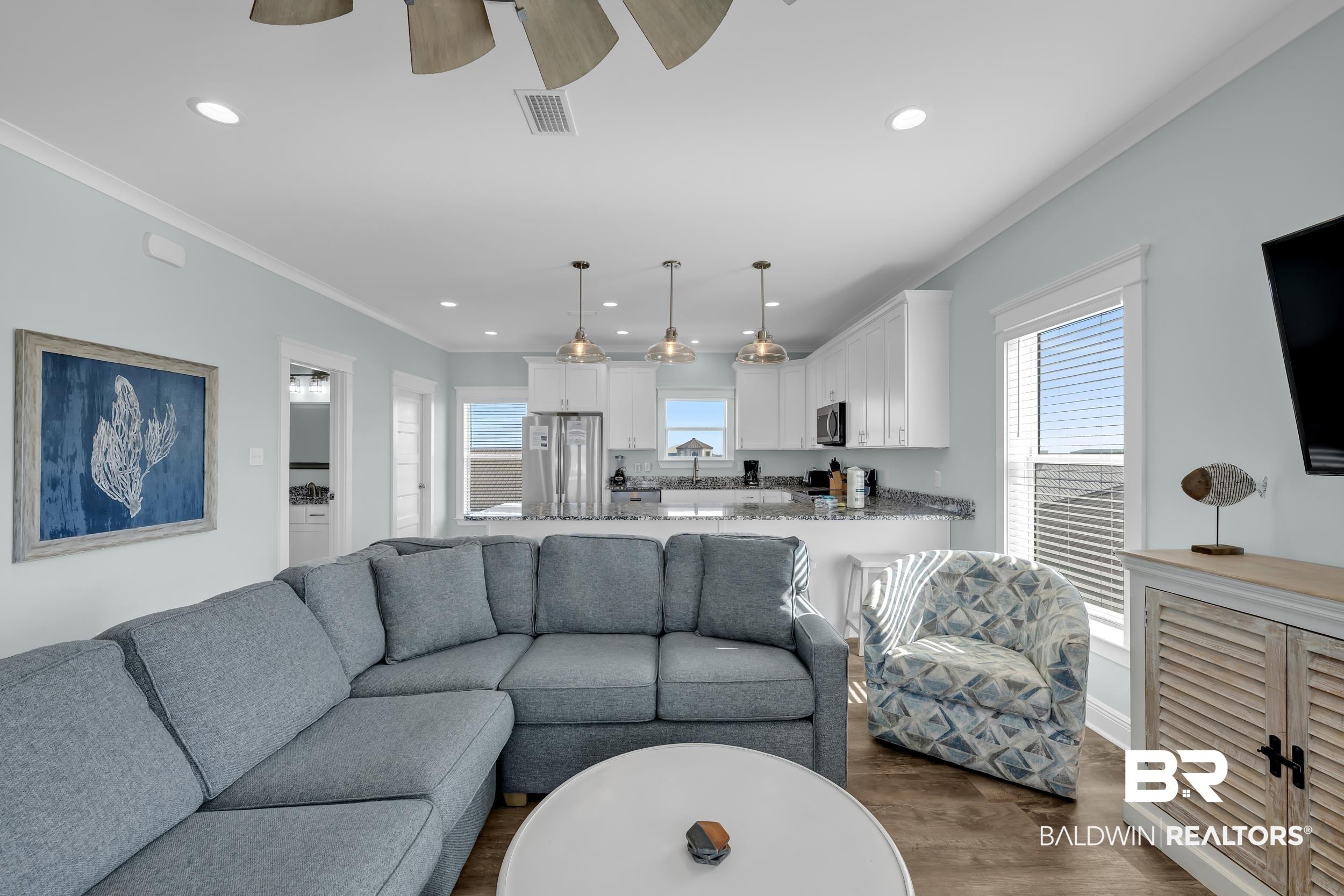 Image 4: Open concept living area featuring wood-finish flooring, recessed lighting, and a ceiling fan