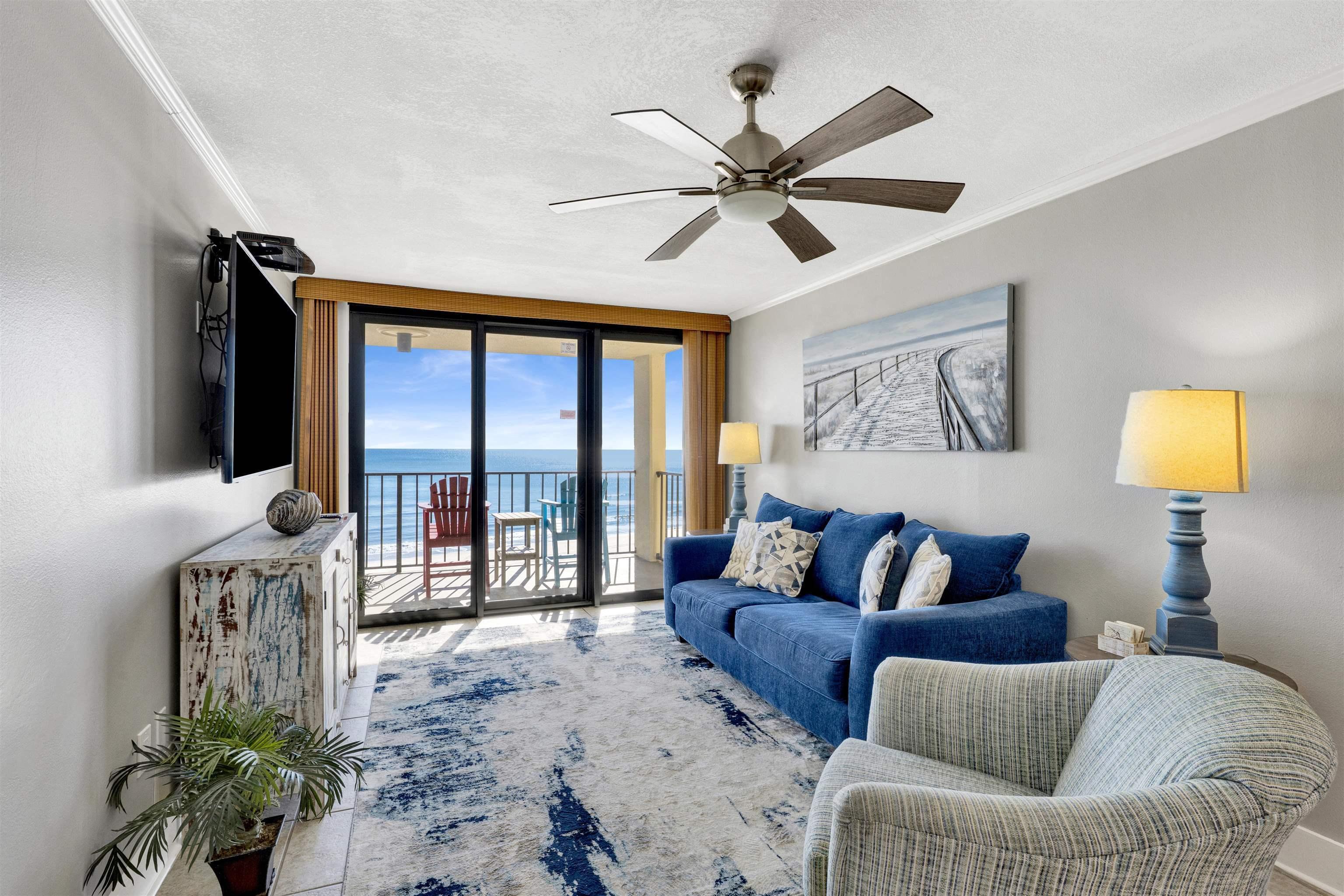 Image 2: Living area featuring expansive windows, ornamental molding, a textured ceiling, and ceiling fan