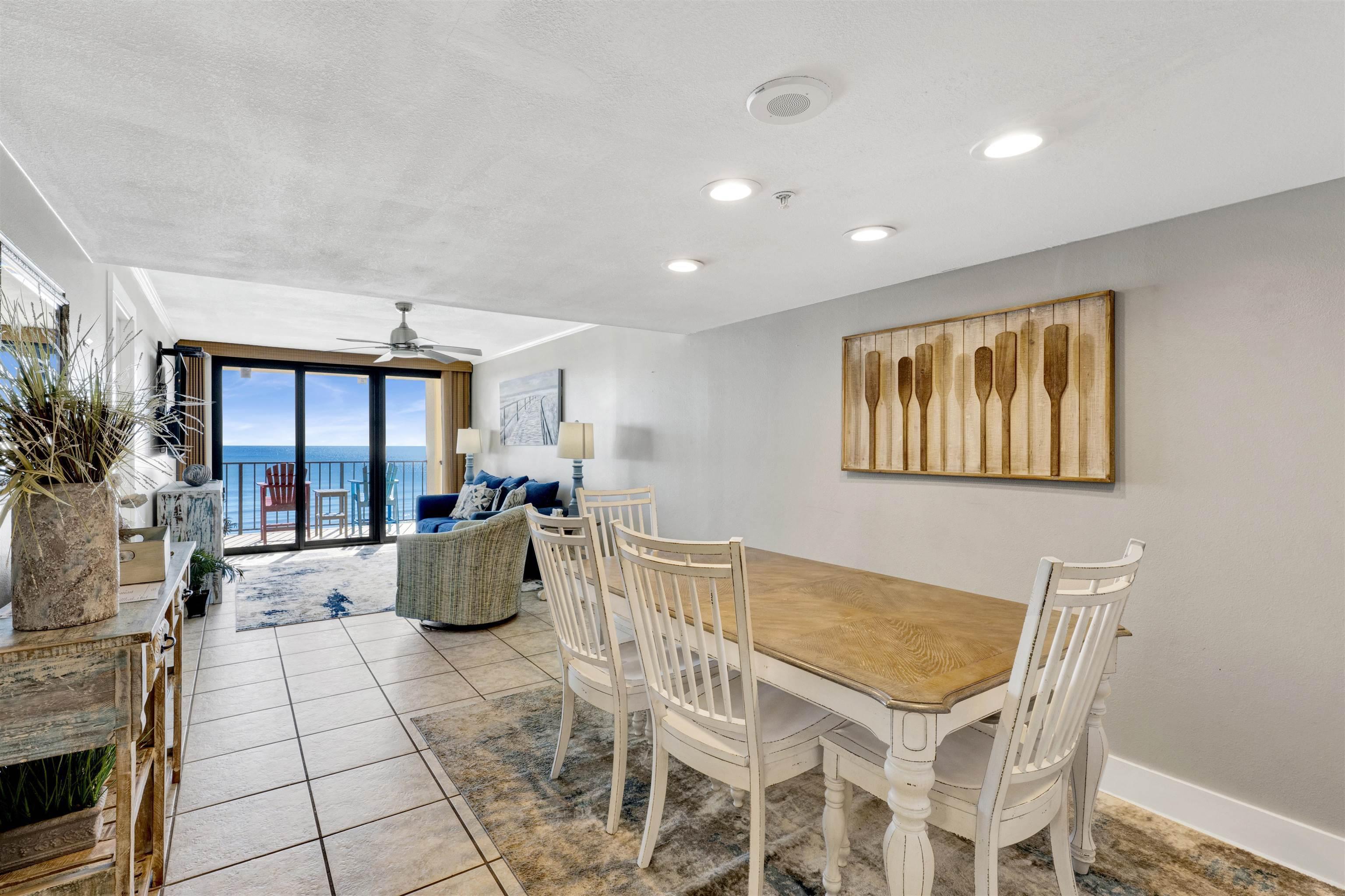 Image 4: Dining room with expansive windows, tile patterned flooring, ceiling fan, a water view, and a textured ceiling