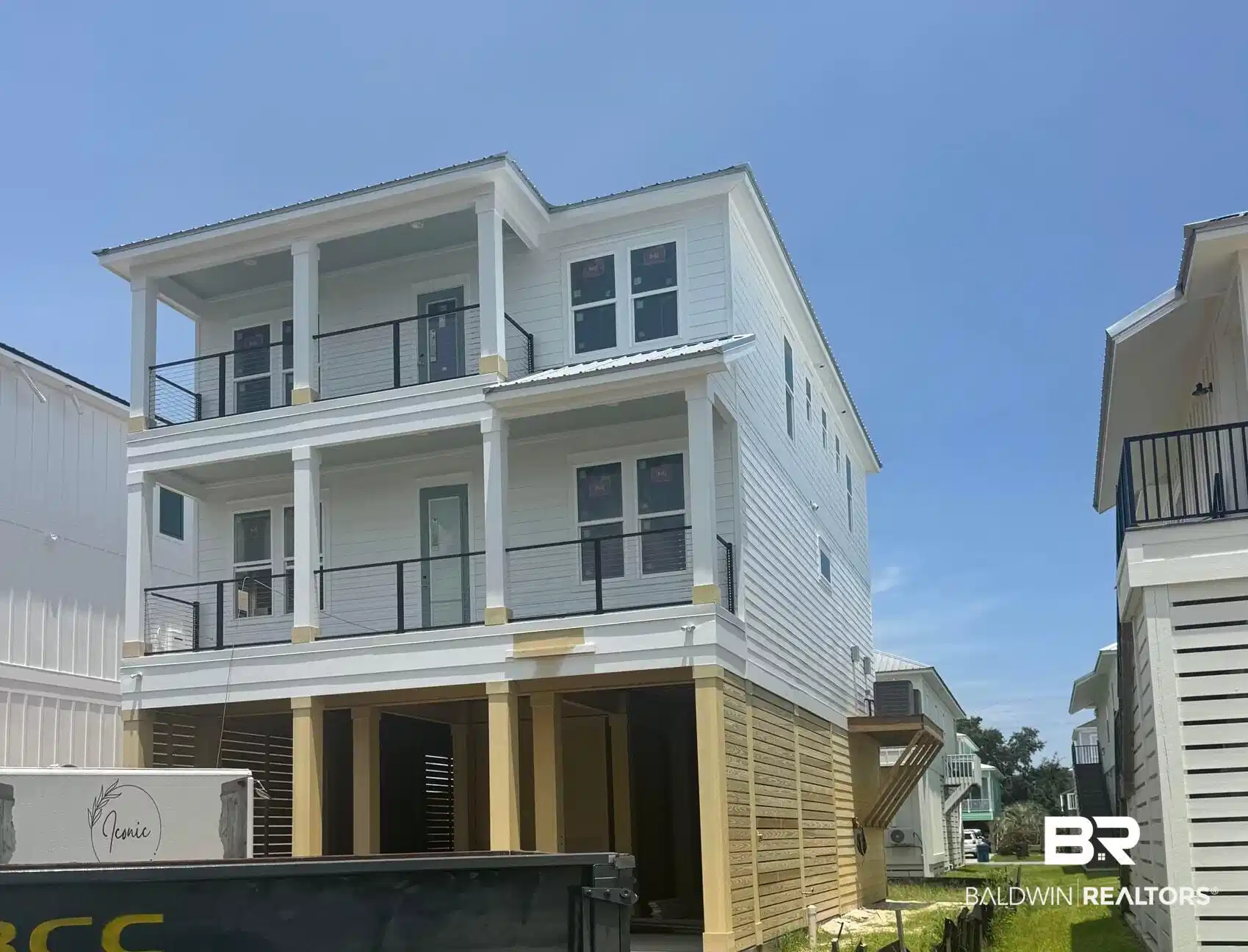 Image 1: Newly constructed multi-level home featuring white siding and a metal roof