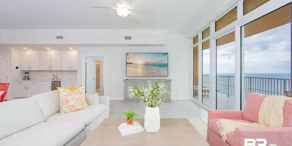 Image 3: Open concept living area with large format tile flooring and a wet bar featuring white cabinetry and a tile backsplash