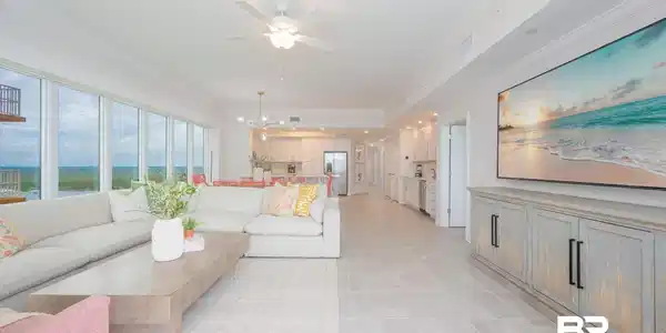 Image 4: Expansive open-concept living area featuring floor-to-ceiling windows, light tile flooring, crown molding, and a contemporary ceiling fan