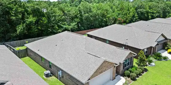 Image 4: Brick exterior home featuring a two-car garage, concrete driveway, and established landscaping