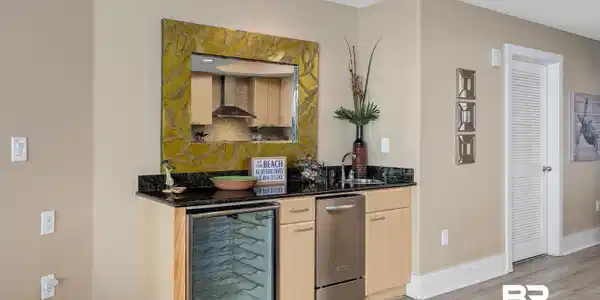 Image 4: Bar with wall chimney exhaust hood, wine cooler, sink, light brown cabinetry, and light hardwood / wood-style floors