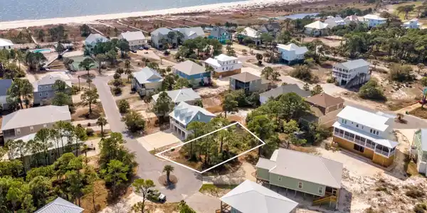 Image 2: Aerial perspective of suburban area featuring a large body of water and property parcel outlined