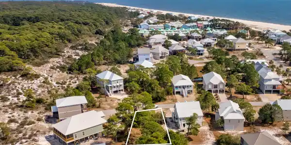 Image 4: Aerial perspective of suburban area featuring property parcel outlined and a nearby body of water