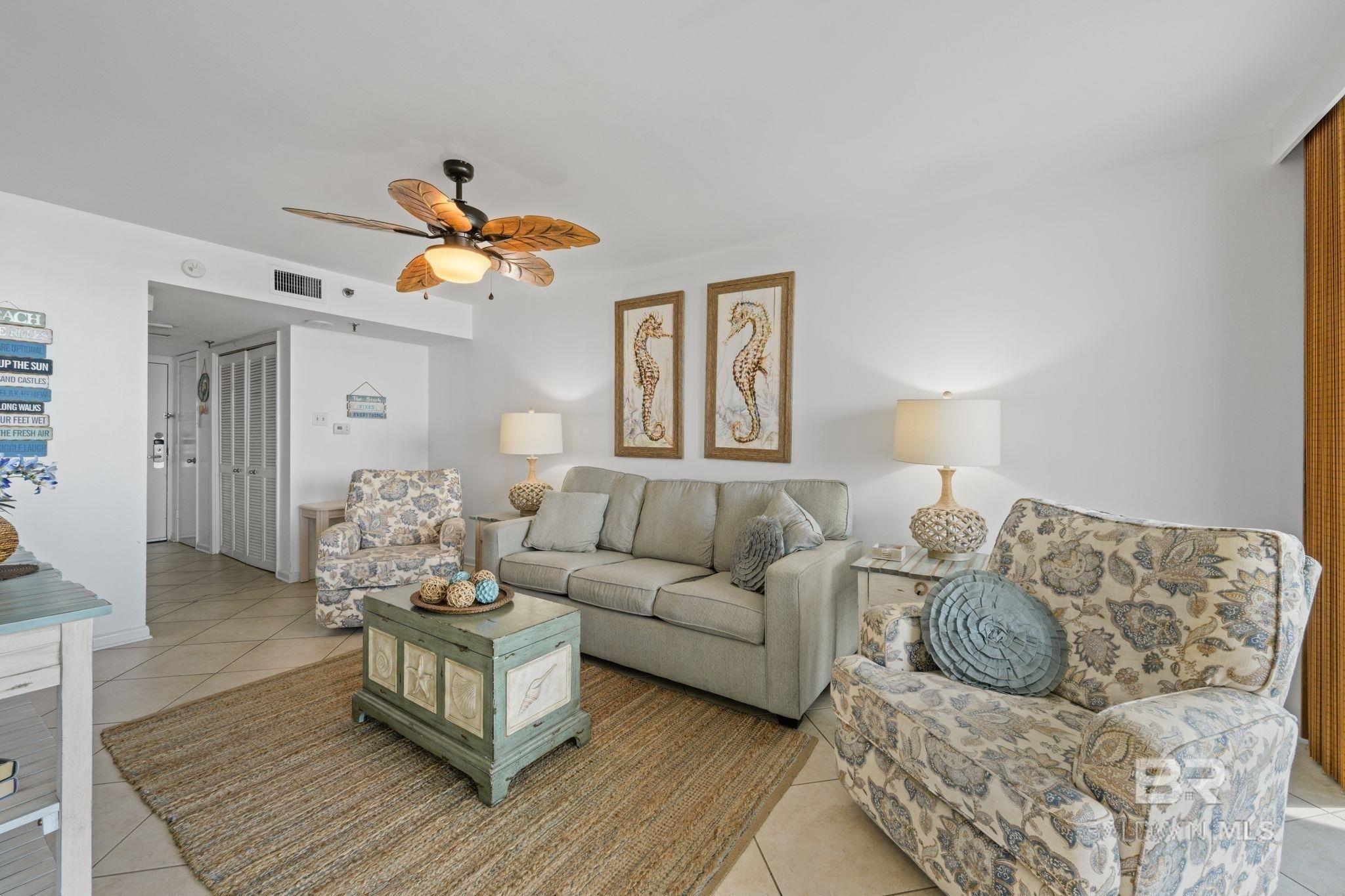 Image 3: Living area featuring light tile patterned floors and a ceiling fan
