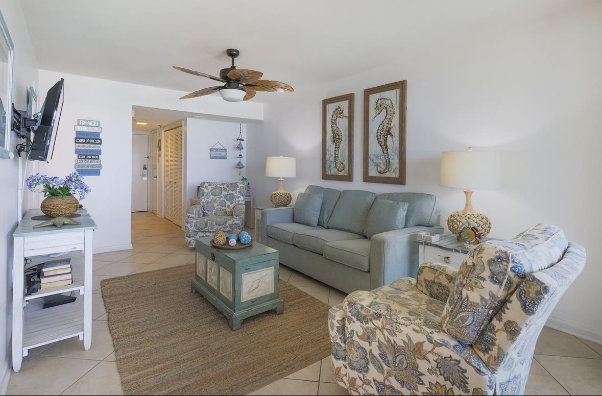 Image 4: Living area with light tile patterned floors and ceiling fan