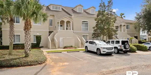 Image 2: View of building exterior featuring stairs and uncovered parking