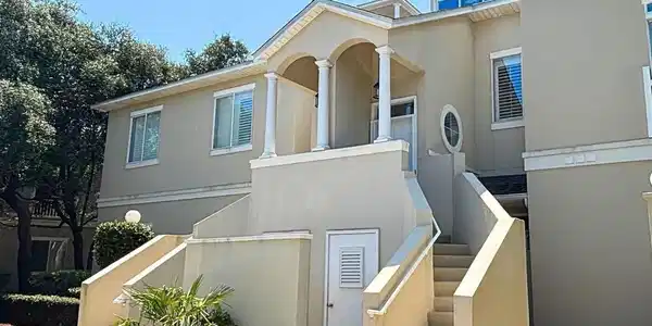 Image 3: View of front facade featuring stucco siding and a balcony