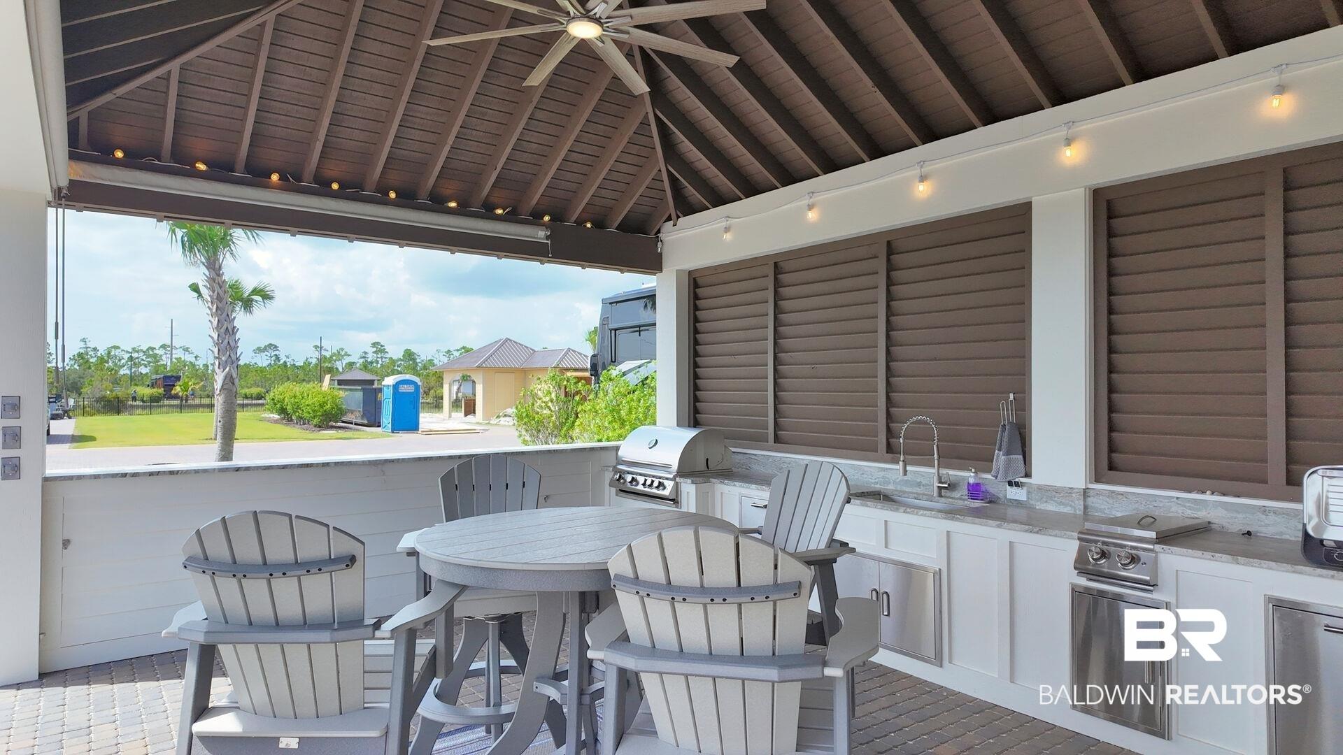 Image 2: View of patio with area for grilling and ceiling fan