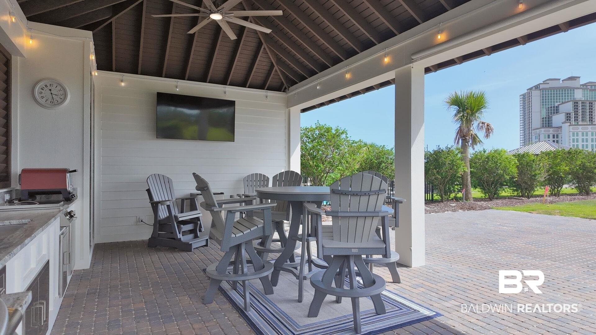 Image 3: View of patio with outdoor dining area, exterior kitchen, and a ceiling fan