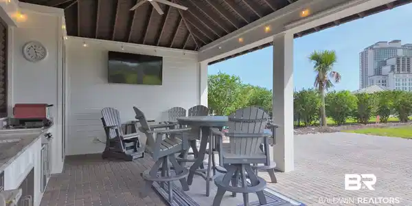 Image 3: View of patio with outdoor dining area, exterior kitchen, and a ceiling fan