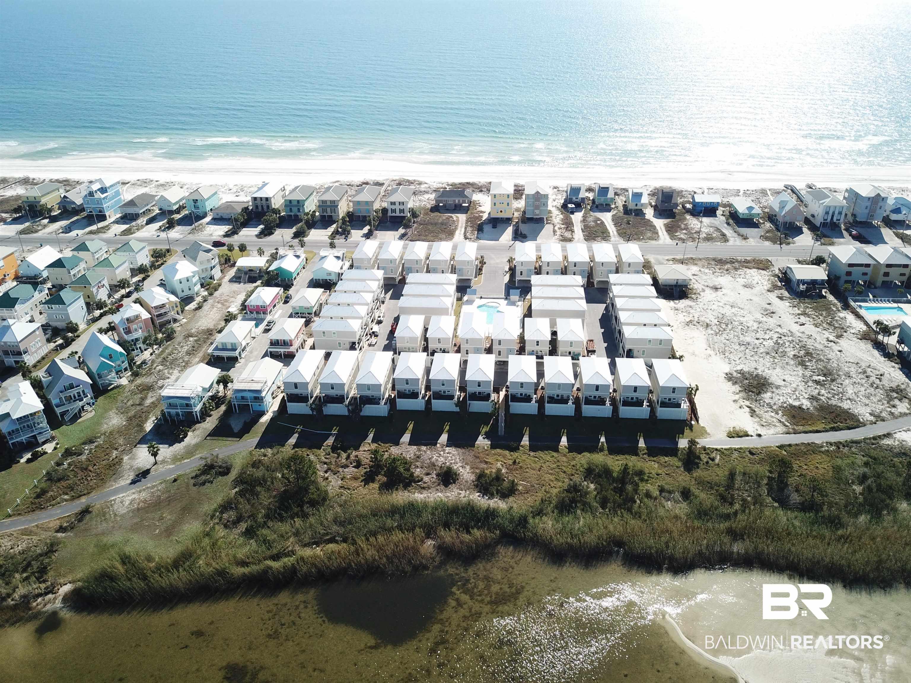 Image 2: Aerial overview of property's location with expansive beach and nearby suburban area