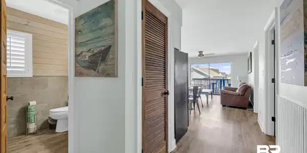 Image 2: Corridor featuring wood finished floors, tile walls, wainscoting, and wood walls
