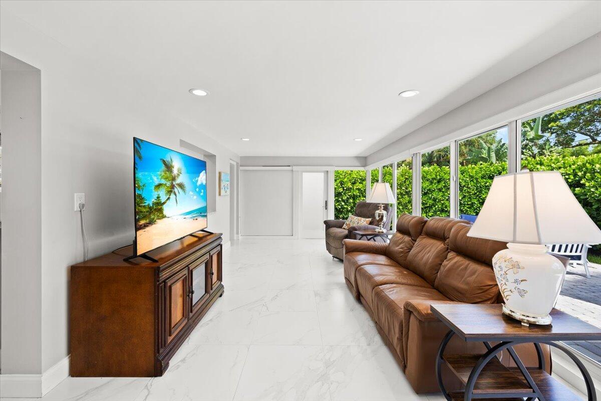 Image 3: Spacious living area featuring light-toned floorin