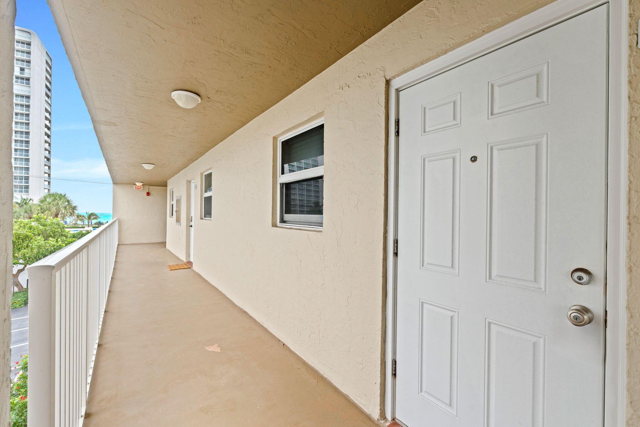 Image 3: Extended outdoor corridor with white railing and w