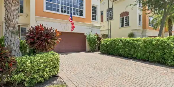 Image 3: Brick paver driveway leading to a two-car garage