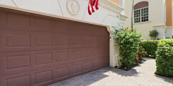 Image 4: Paver driveway with a panel-style garage door and