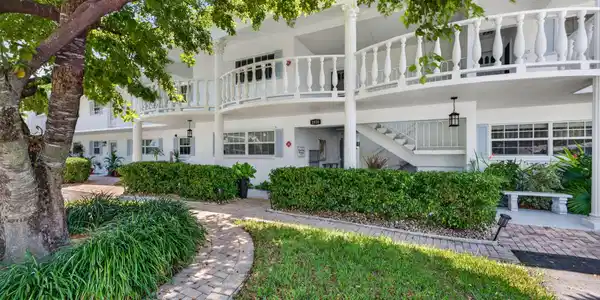 Image 3: Multi-story building exterior featuring white cat