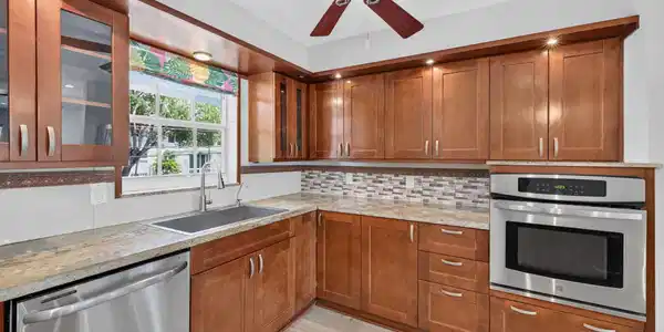 Image 4: Wood-finish cabinetry with recessed lighting, stai