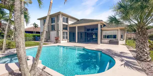 Image 4: View of the back of the home and pool from the bac