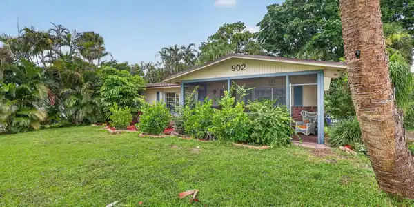 Image 3: Expansive front lawn with mature landscaping and a