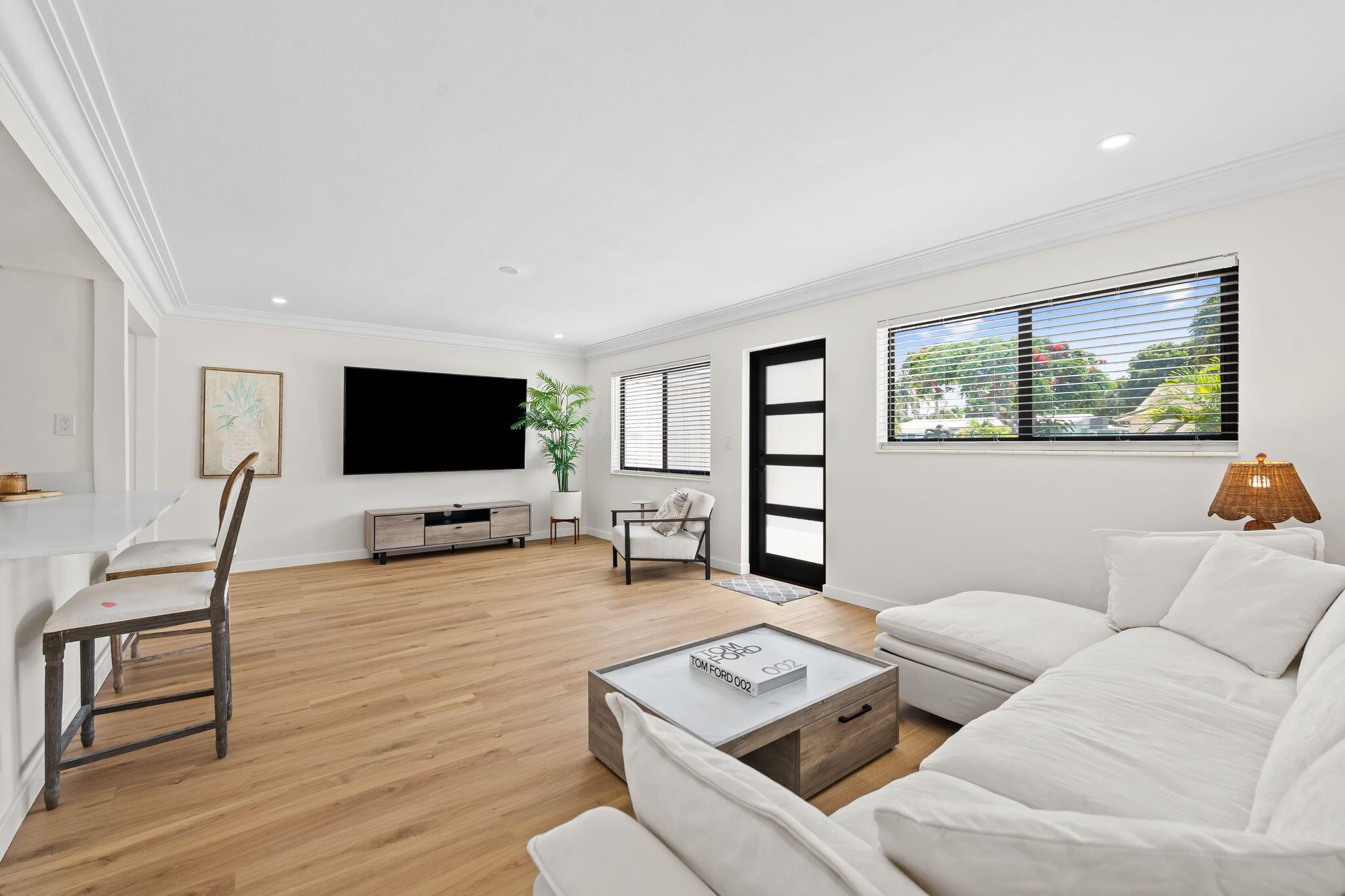 Image 2: Spacious living area featuring wood-finish floorin