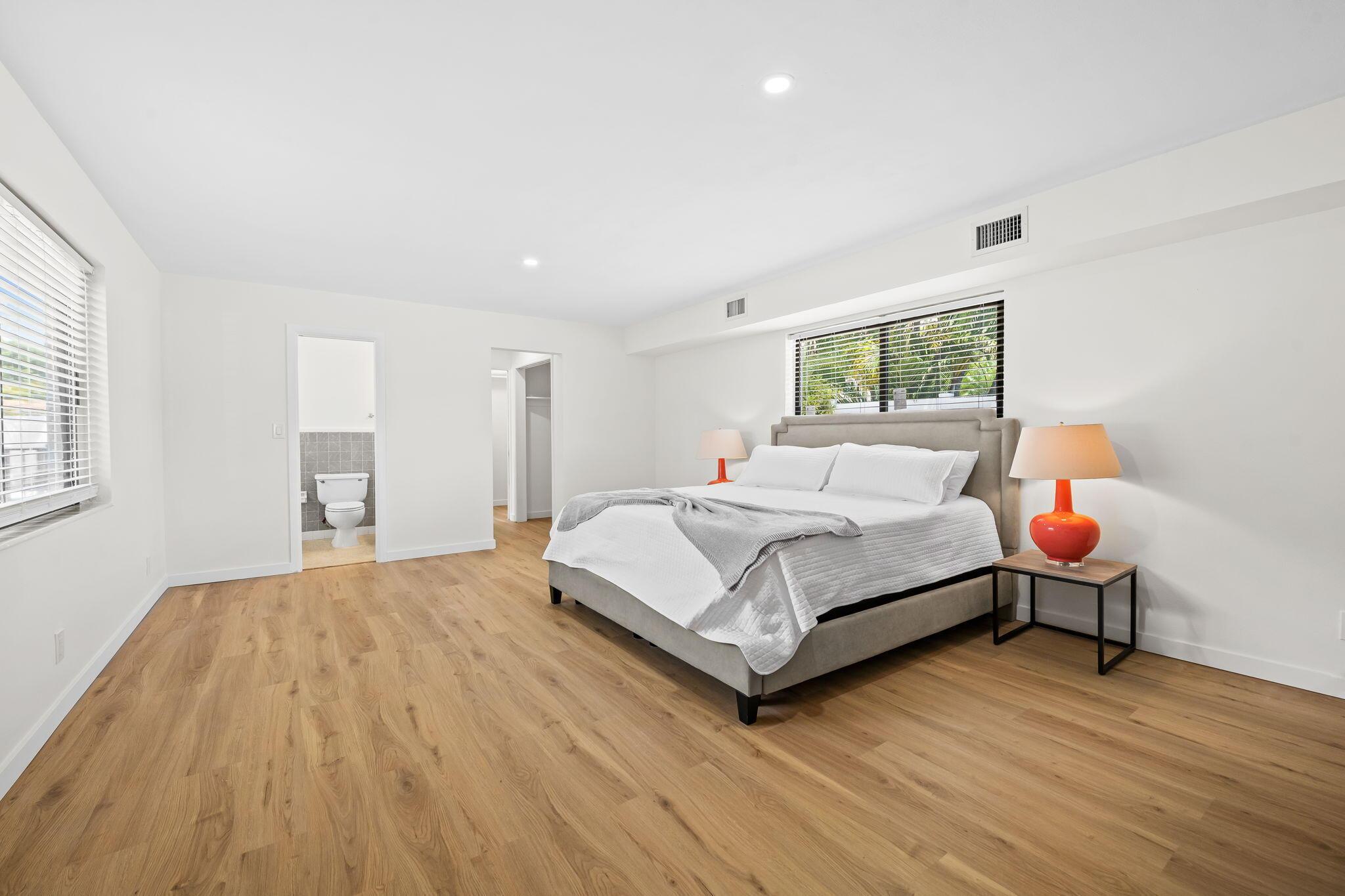 Image 4: Spacious primary bedroom featuring wood-finish flo