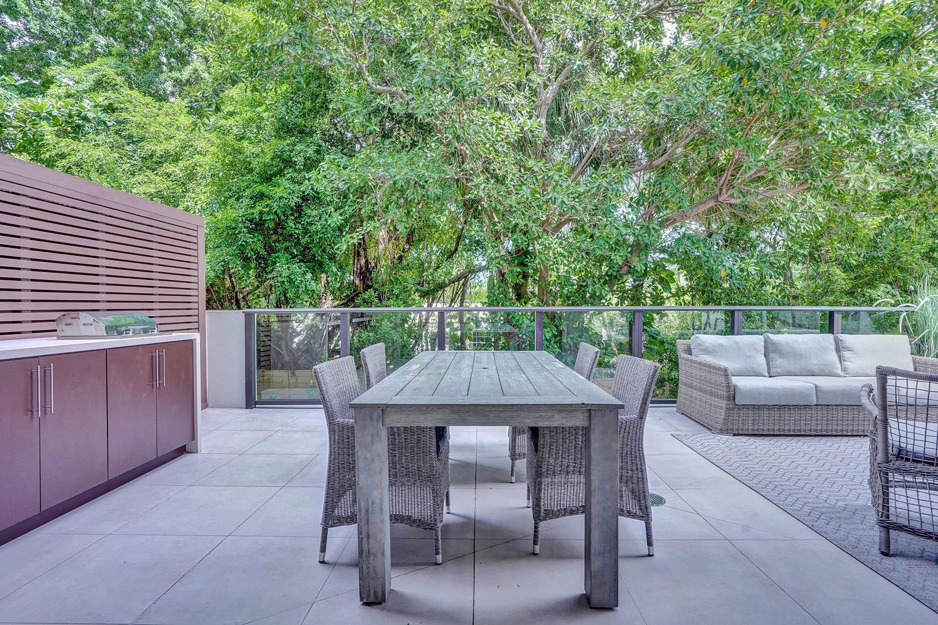Image 3: Expansive outdoor terrace featuring light-toned la