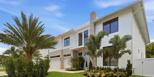 Image 4: Modern white stucco exterior with a stone-clad chi