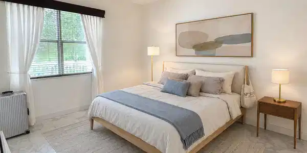 Image 4: Bedroom featuring a window with blinds and sheer w