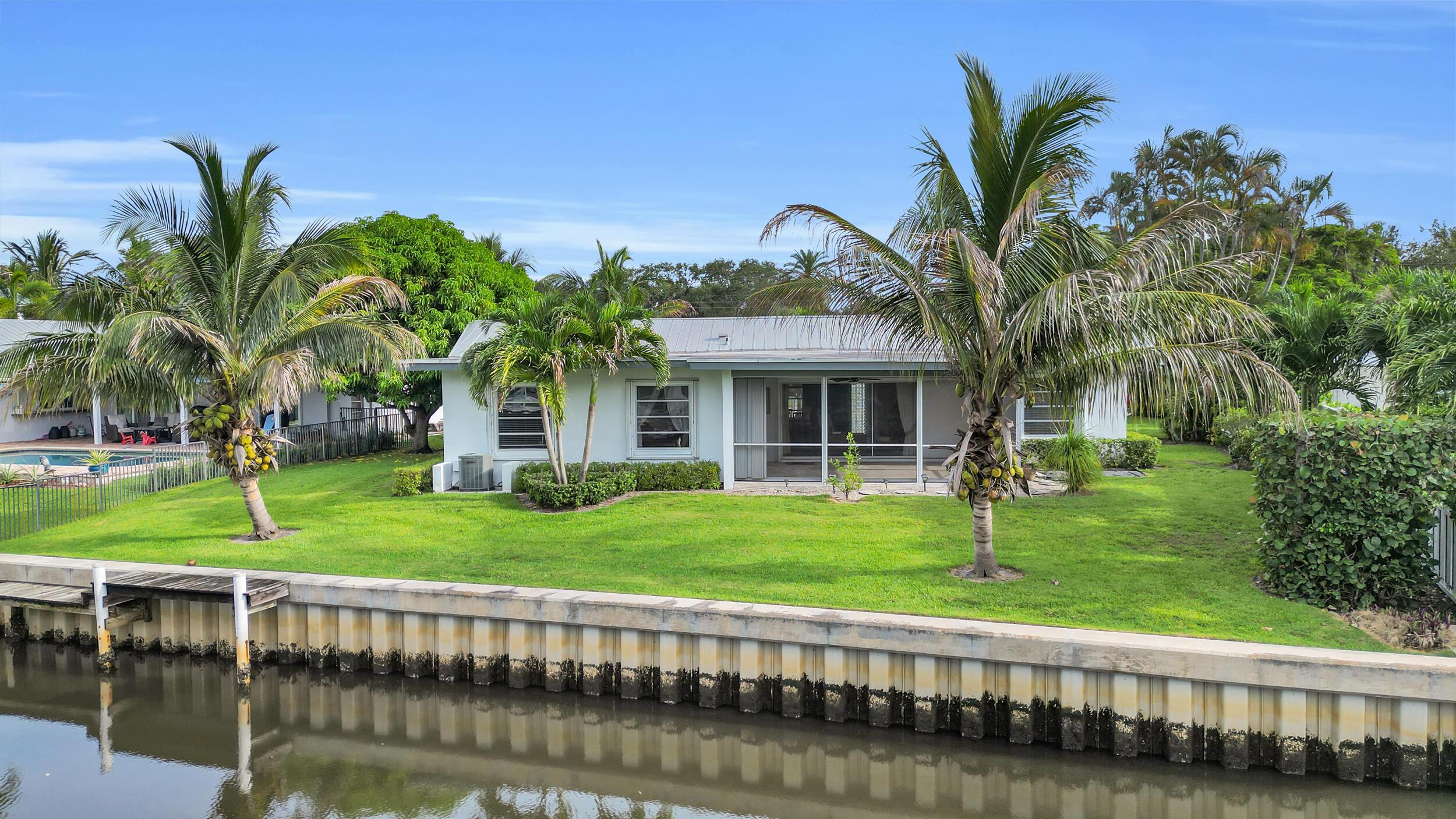 Image 2: Waterfront home featuring a modern white exterior