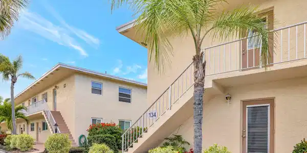 Image 2: Bright exterior with palm trees and cheerful bloom