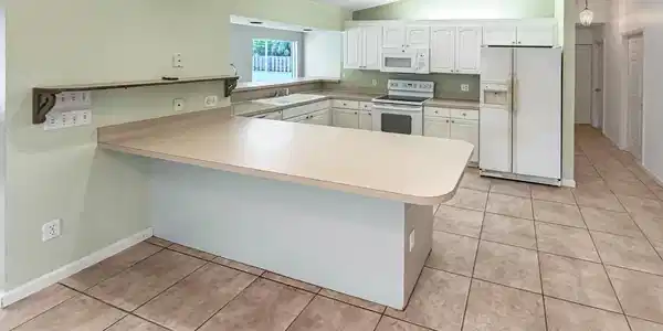 Image 2: Kitchen featuring a peninsula counter with ample s