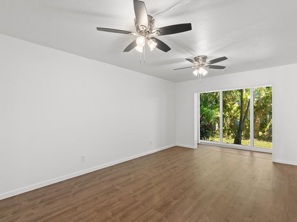 Image 3: Spacious room featuring wood-finish flooring, whit