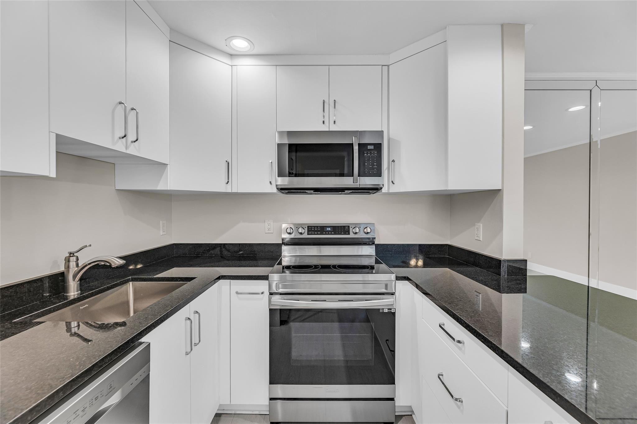 Image 2: Custom cabinets and stainless steel appliances
