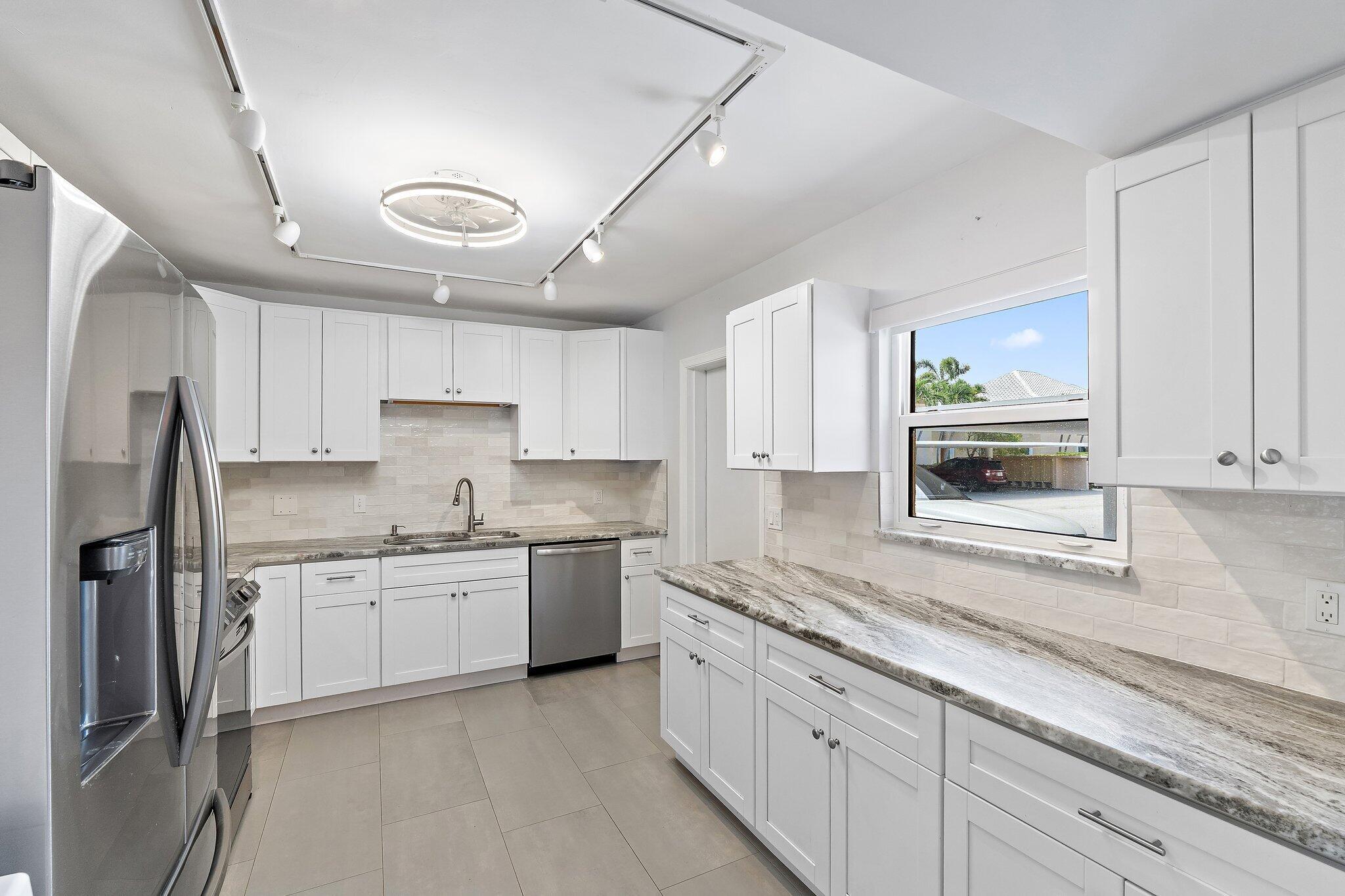 Image 3: Updated kitchen with white shaker cabinets, stone