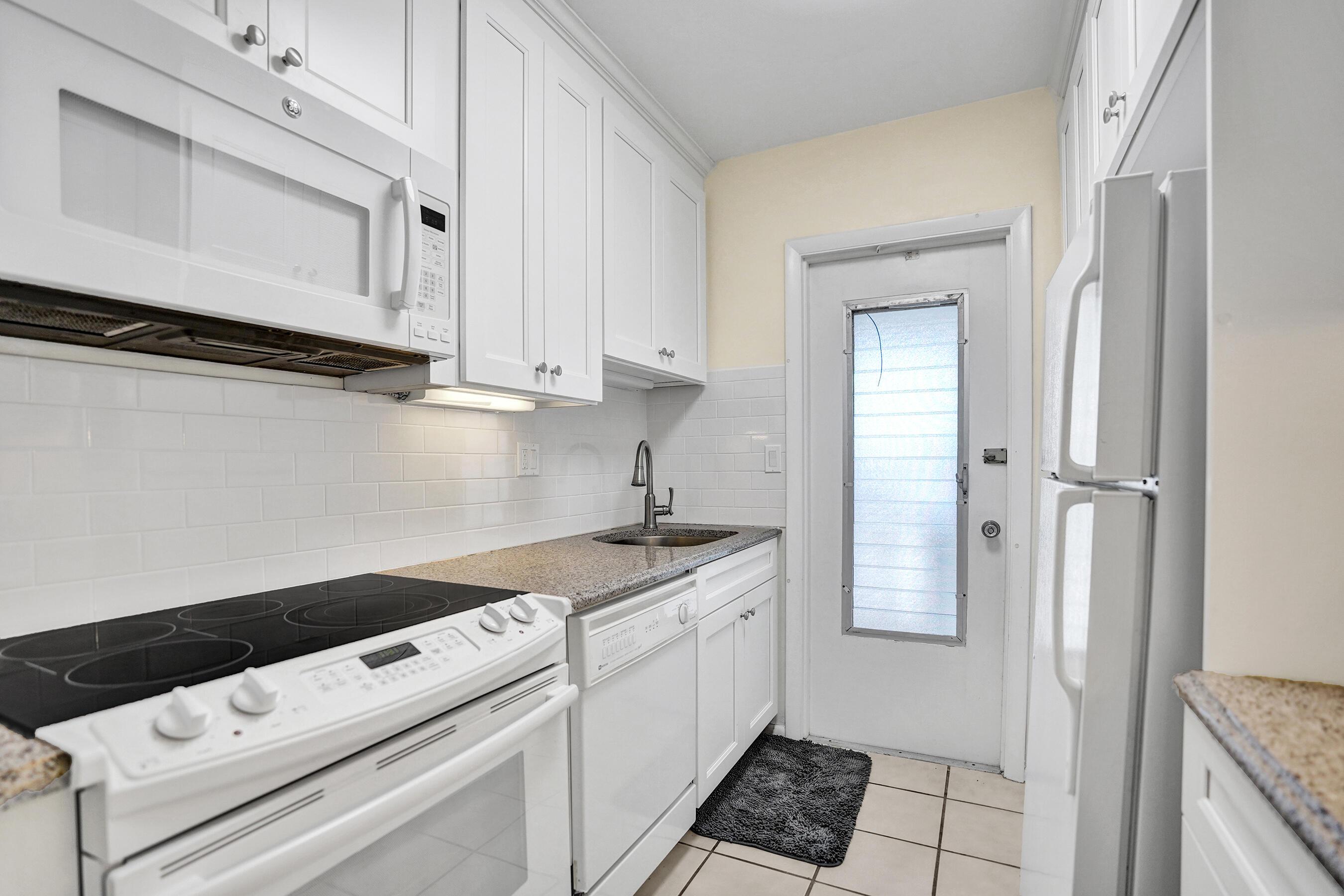 Image 3: Kitchen featuring white cabinetry with silver hard