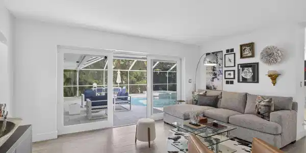 Image 4: Sliding glass doors opening to a screened lanai wi
