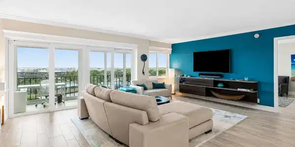 Image 4: Living room has sliders to a glass enclosed balcon