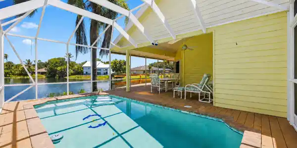 Image 3: Screened-in pool deck featuring a swimming pool, w