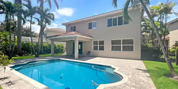 Image 2: Full rear exterior with pool and covered lanai.