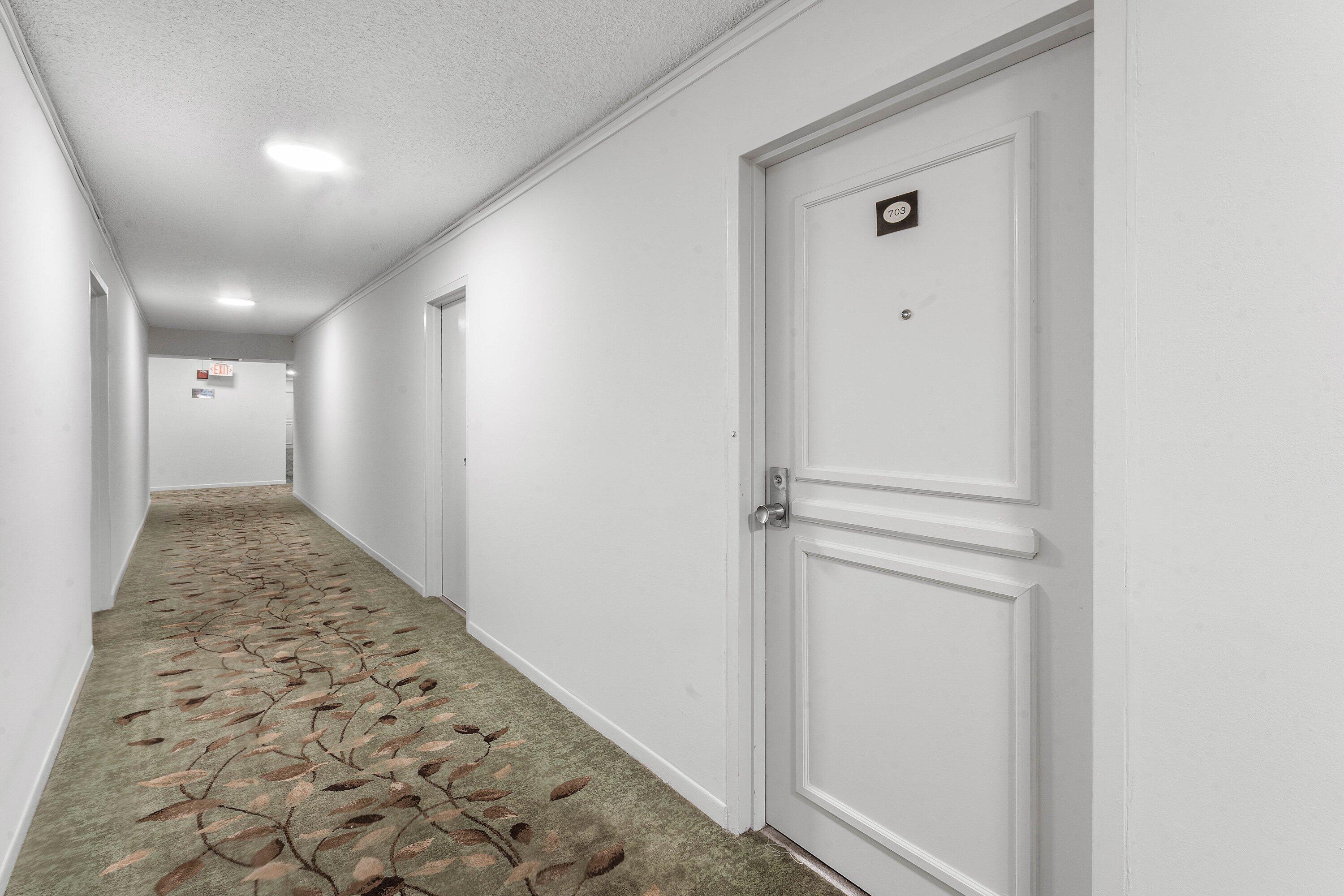 Image 2: Corridor featuring a patterned carpet runner, whit