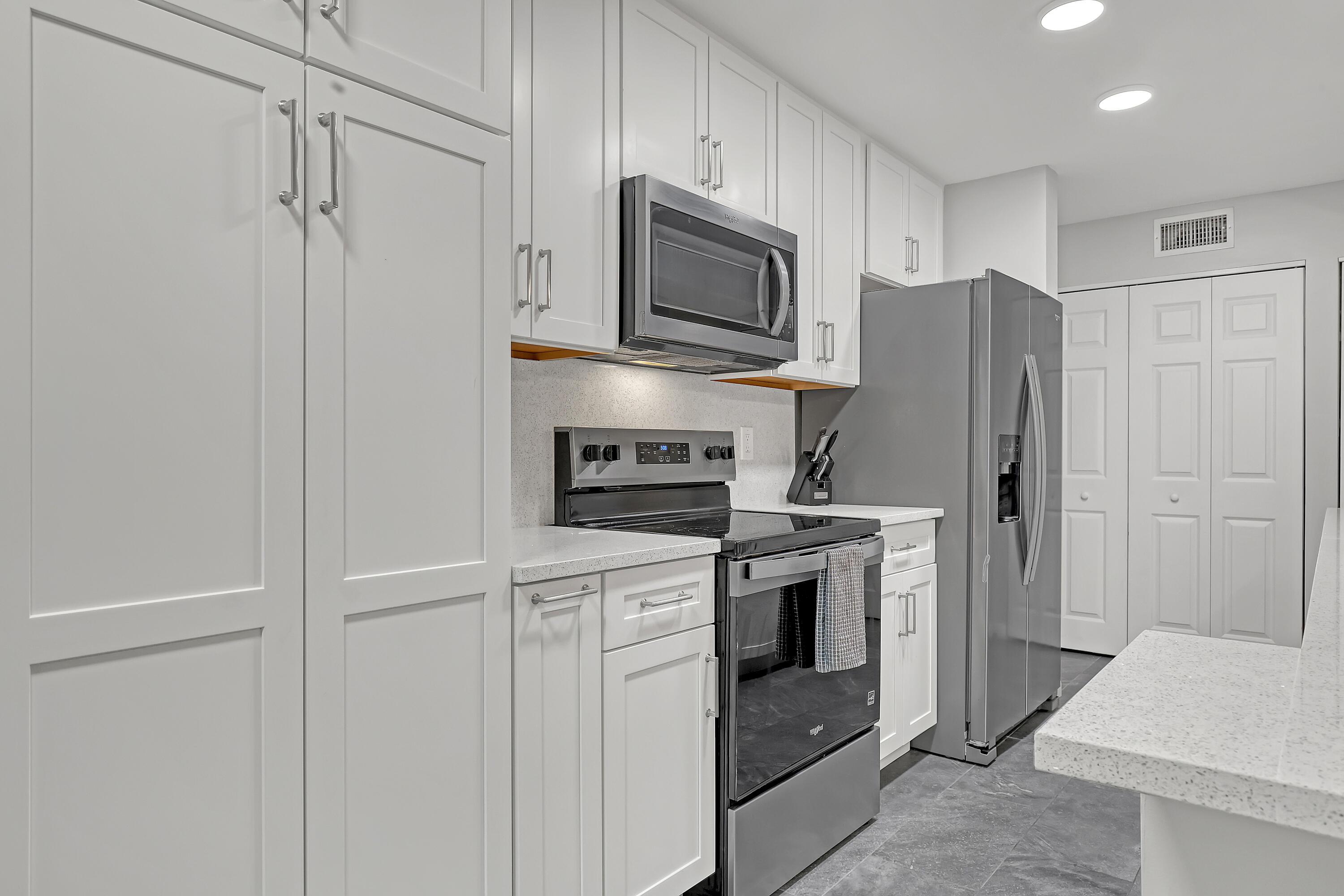 Image 4: Crisp white cabinetry and ample counter space prov