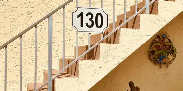 Image 2: Staircase featuring metal railings, textured stucc