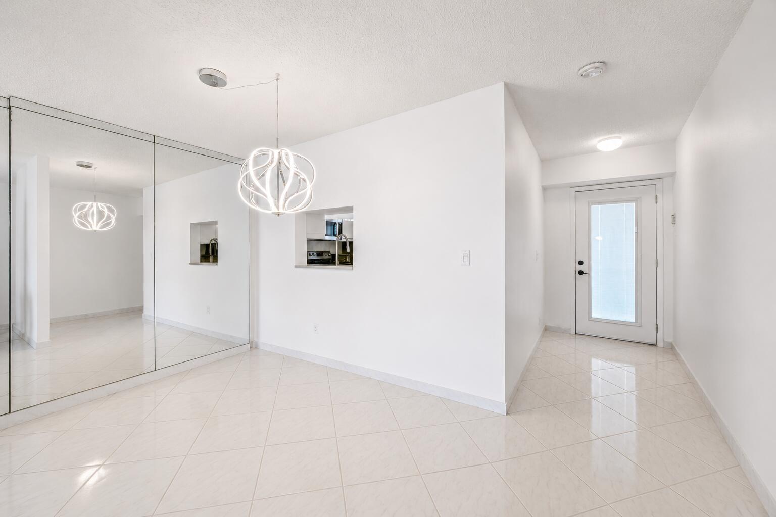Image 3: Bright, open entryway showcasing polished tile flo